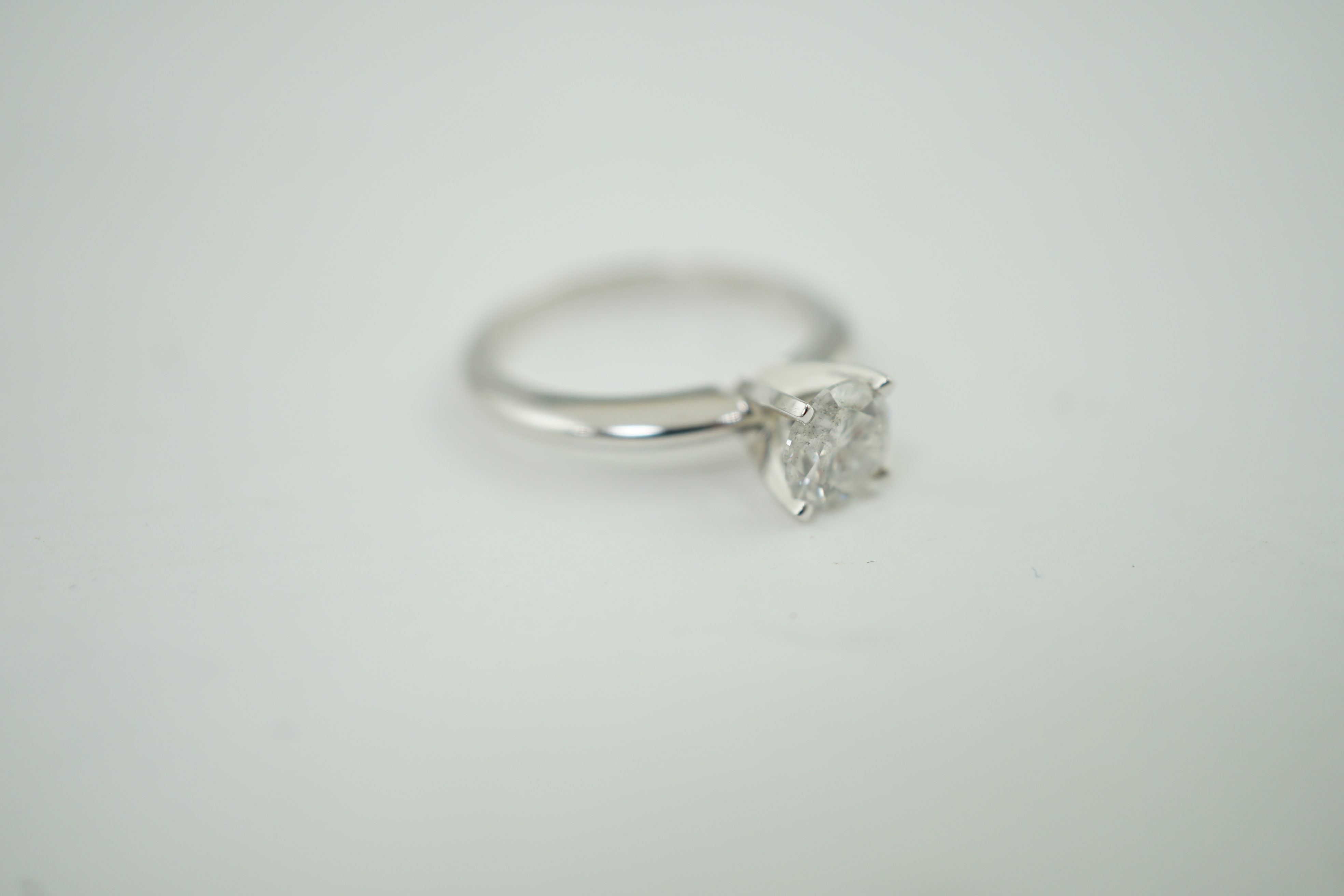 A modern 14k gold and solitaire diamond set ring